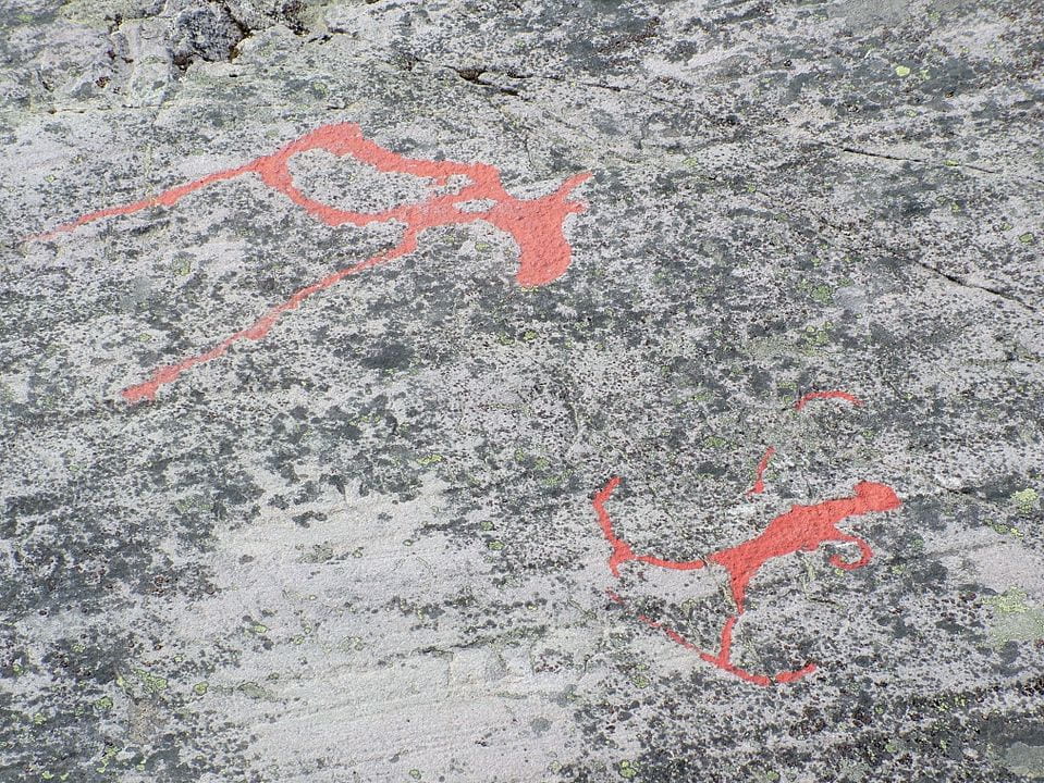 rock painting of hunter on skis shooting moose with bow and arrow