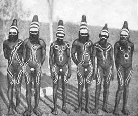 Aboriginal male dancers standing in a line showing body paint